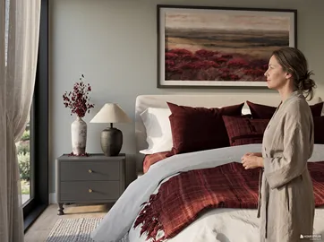 woman standing in elegantly designed bedroom with modern decor and cozy details showcasing warm tones and soft textures, utilizing Homestyler's real-time 3D rendering for visualization