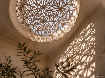 Intricate ceiling design filtering light with shadow patterns in a cozy interior space, showcasing a modern rustic style with the Homestyler feature of real-time 3D rendering for design proposals.