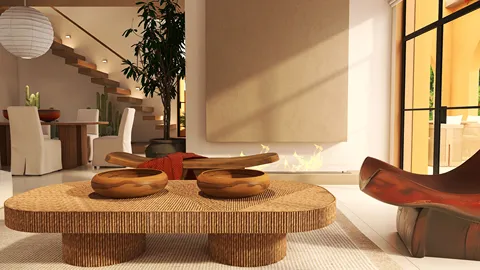 Warm wooden coffee table with circular bowls arranged in a modern living room, featuring a cozy atmosphere with minimalist decor and natural light, showcasing interior design using Homestyler's real-time 3D rendering feature.